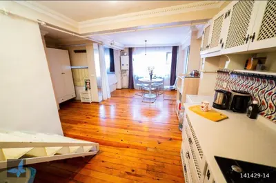 a living room with a wooden floor and a kitchen at Taksim FunHouse in Istanbul