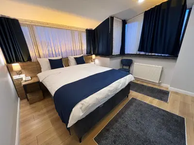 a bedroom with a large bed and two windows at The Blue Suites in Istanbul