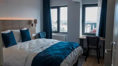 a bedroom with a bed and a desk and two windows at The Blue Suites in Istanbul