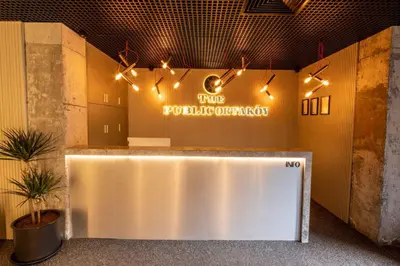 a lobby with a white reception counter with lights at The Public Ortakoy in Istanbul