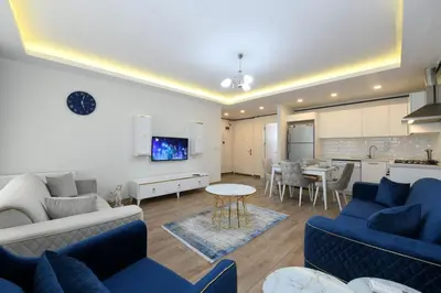 a living room with blue couches and a kitchen at Kardeş Suite 5 in Istanbul