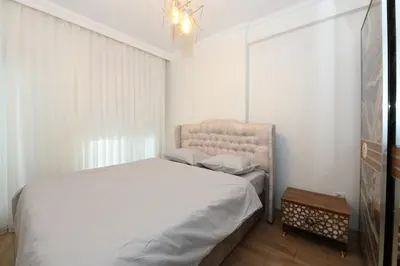 a bedroom with a bed and a chair and a chandelier at Kardeş Suite 5 in Istanbul