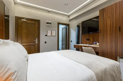 a bedroom with a large white bed and a desk at Dream Park Hotel in Istanbul