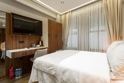 a bedroom with a bed and a desk and a television at Dream Park Hotel in Istanbul