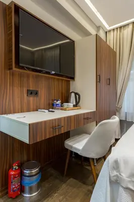 a room with a desk with a tv and a chair at Dream Park Hotel in Istanbul