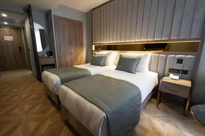 a hotel room with two beds and a night stand at Buke Hotel Bomonti in Istanbul