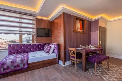 a bedroom with a purple bed and a table at Rose Apartments in Istanbul