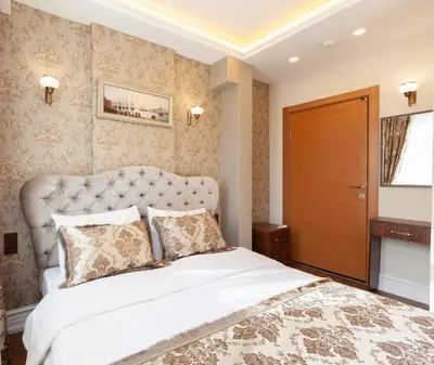 a bedroom with a large white bed with a large headboard at Rose Apartments in Istanbul