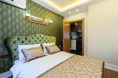 a bedroom with a large bed with a green headboard at Rose Apartments in Istanbul