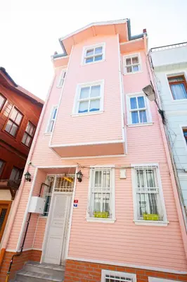 a pink house with a white door and windows at Rose Apartments in Istanbul