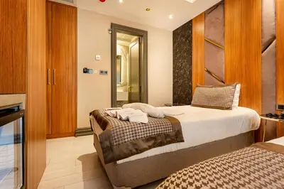 a bedroom with a large bed and a kitchen at Santra Hotel in Istanbul