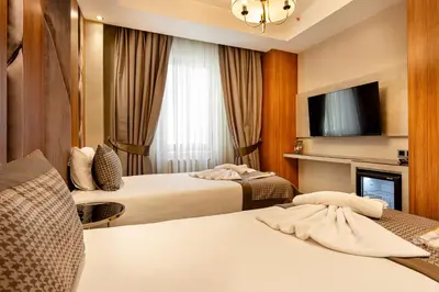 a hotel room with two beds and a tv at Santra Hotel in Istanbul