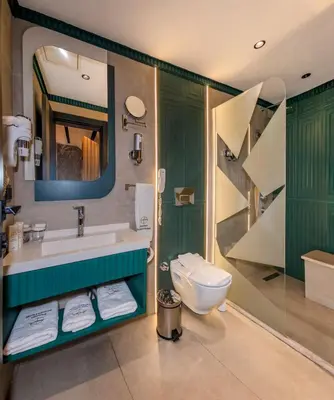 a bathroom with a sink and a toilet and a mirror at Elysian Airport Hotel & Restaurant in Arnavutköy