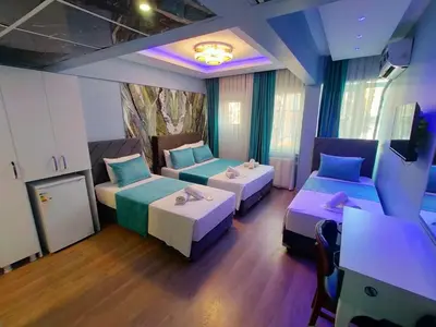 a hotel room with two beds and a table at Grand Bona Sera Hotel in Istanbul