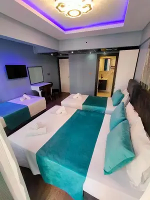 a hotel room with two beds and a tv at Grand Bona Sera Hotel in Istanbul