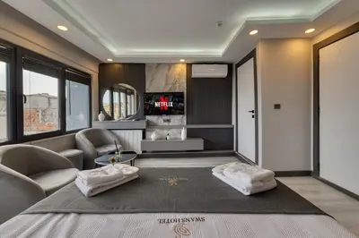 a room with a living room with a tv and a couch at Swans Hotel Old City Grand Bazar in Istanbul