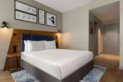 a bedroom with a large white bed and a door at Ramada Encore by Wyndham Istanbul Arnavutkoy in Istanbul