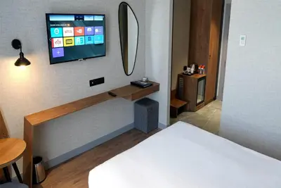 a bedroom with a bed and a tv on a wall at Ramada Encore by Wyndham Istanbul Arnavutkoy in Istanbul
