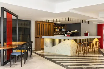 a restaurant with a bar with chairs and tables at Ramada Encore by Wyndham Istanbul Arnavutkoy in Istanbul