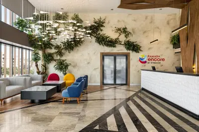 a lobby with a waiting area with plants on the wall at Ramada Encore by Wyndham Istanbul Arnavutkoy in Istanbul