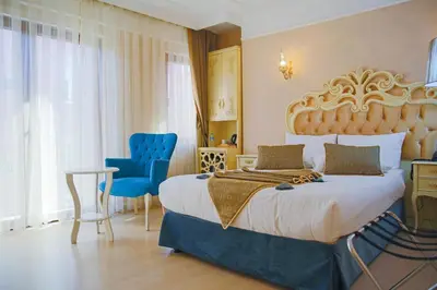 a bedroom with a large bed and a blue chair at Edibe Sultan Hotel in Istanbul