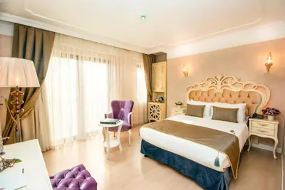 a hotel room with a large bed and purple furniture at Edibe Sultan Hotel in Istanbul