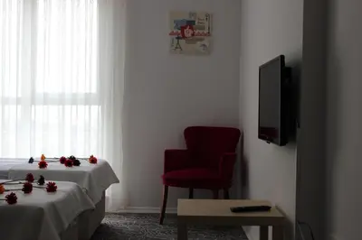 a room with a red chair and a table and a tv at KAT11 in Beylikduzu