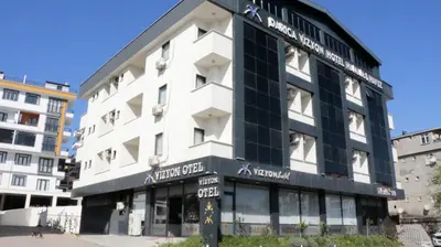 a large white building with a black facade at Vizyon Otel Darıca in Darıca