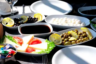 a table topped with white plates and bowls of food at Vizyon Otel Darıca in Darıca