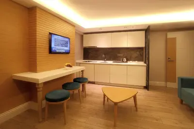 a kitchen with a counter and stools and a table at Carina Park Suites Nisantasi in Istanbul