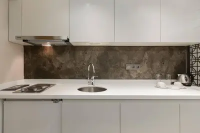 a kitchen with white cabinets and a sink at Carina Park Suites Nisantasi in Istanbul