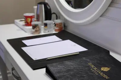 a desk with a notebook and a book on a plane at Luxor Garden Hotel in Kocaeli