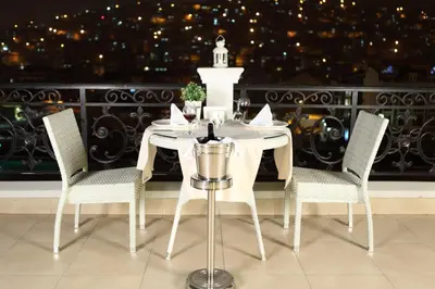 a white table and chairs with a view of a balcony at Luxor Garden Hotel in Kocaeli
