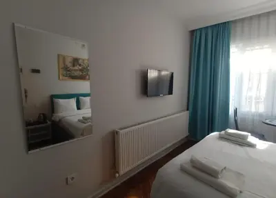 a hotel room with a bed and a mirror at Buyukada Cinar Hotel in Buyukada