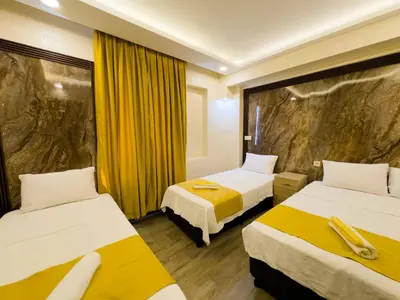 a hotel room with two beds and yellow curtains at Öz Dünya Hotel in Istanbul