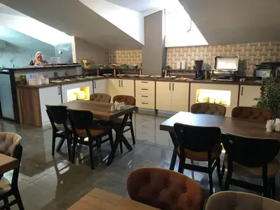 a restaurant with tables and chairs and a kitchen at Era Palace Hotel in Istanbul