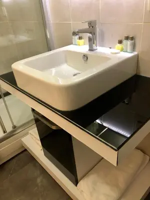 a bathroom with a white sink on a glass counter at Era Palace Hotel in Istanbul