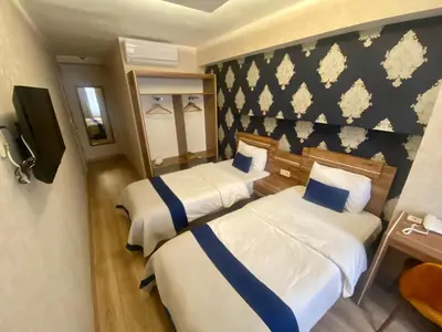 a hotel room with two beds and a tv at Era Palace Hotel in Istanbul