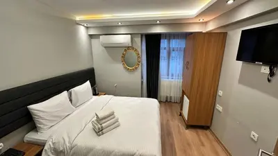 a bedroom with a bed with white sheets and a television at Mamma Marya Hotel in Istanbul