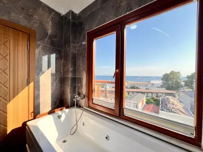 a bathroom with a bath tub and a window at Mamma Marya Hotel in Istanbul