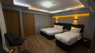 a hotel room with two beds and a chair at Mamma Marya Hotel in Istanbul
