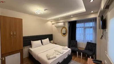 a bedroom with a bed and a chair and a window at Mamma Marya Hotel in Istanbul