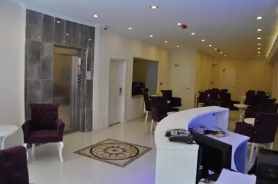 a waiting room with chairs and a reception desk at Hotel Iscen in Mustafakemalpaşa