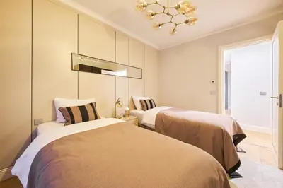 two beds in a room with a chandelier at Taksim Lagirio Residence in Istanbul