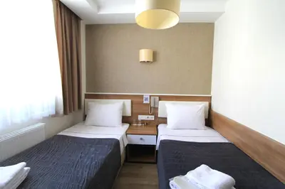 a hotel room with two beds and a desk at Metrohill Hotel in Istanbul