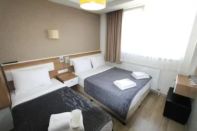 a hotel room with two beds and a desk at Metrohill Hotel in Istanbul