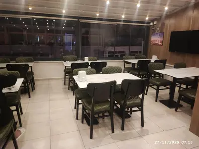 a dining room with tables and chairs and a tv at Metrohill Hotel in Istanbul