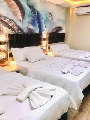 three beds in a room with a mural on the wall at Bonita Hotel in Istanbul