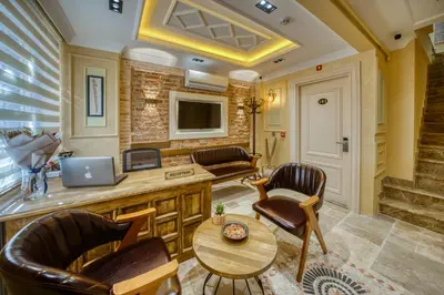 a living room with chairs and a table and a laptop at Mahhsen Mansion Oldcity in Istanbul