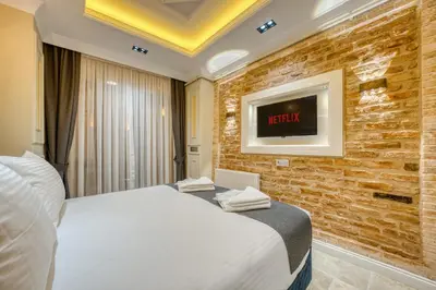 a hotel room with a bed and a tv on a brick wall at Mahhsen Mansion Oldcity in Istanbul